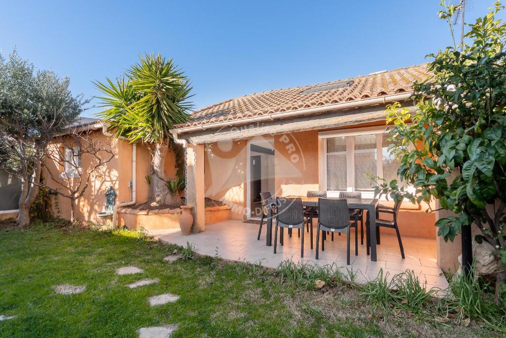 un patio avec une table et des chaises devant une maison dans l'établissement AS19011- P2 climatisé avec wifi proche de la plage, au Grau-du-Roi