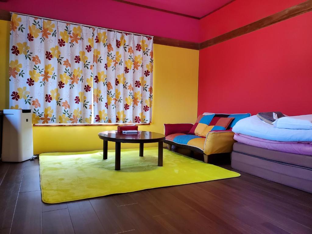 um quarto com uma cama, uma mesa e uma janela em Naoshima Kowloon em Naoshima