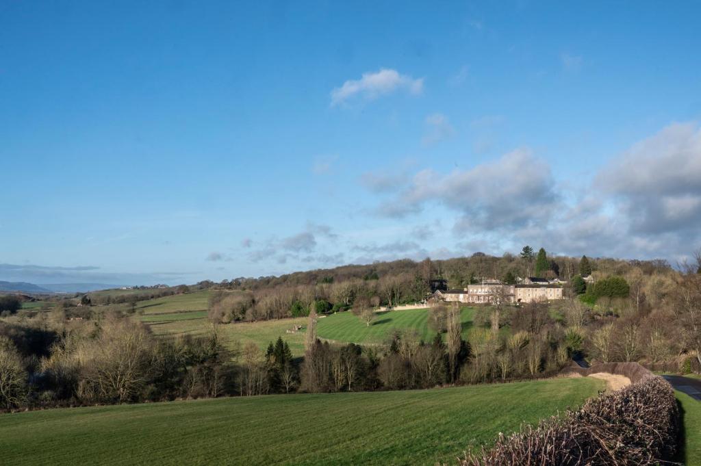 una casa en una colina en un campo verde en Wood Hall Hotel & Spa en Wetherby