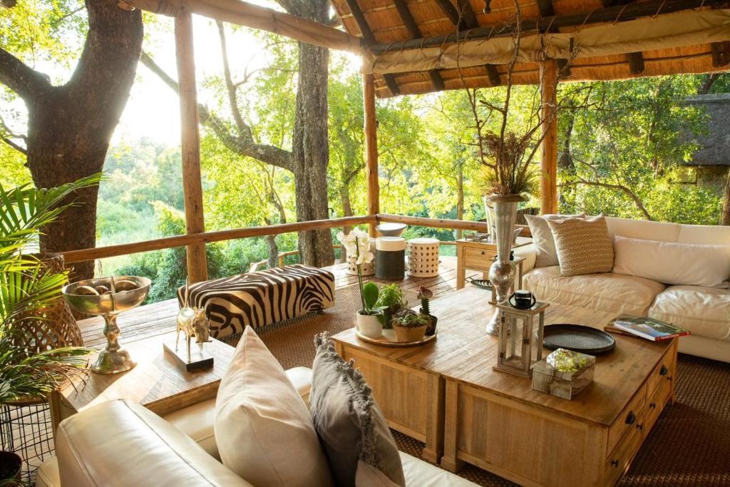 a screened in porch with a couch and a table at Karongwe Portfolio - Kuname Lodge in Karongwe Game Reserve