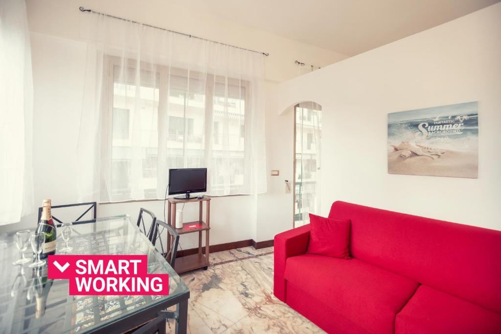 a living room with a red couch and a tv at Sanremo City Center II by Wonderful Italy in Sanremo