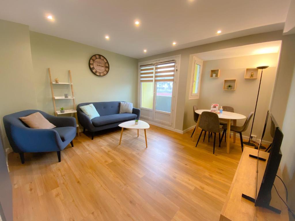 een woonkamer met een bank en een tafel bij Appartement renove et moderne L'Eustache in Calais