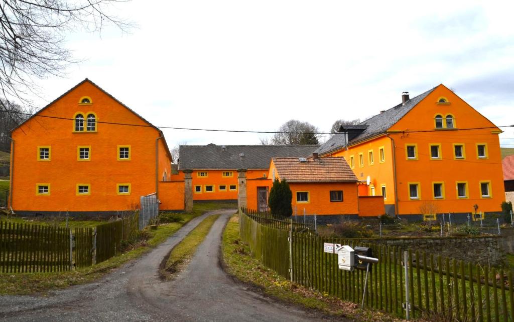 Liebstadt的住宿－Ferienwohnung Klüger Seitenhain，土路上的一群橙色房子