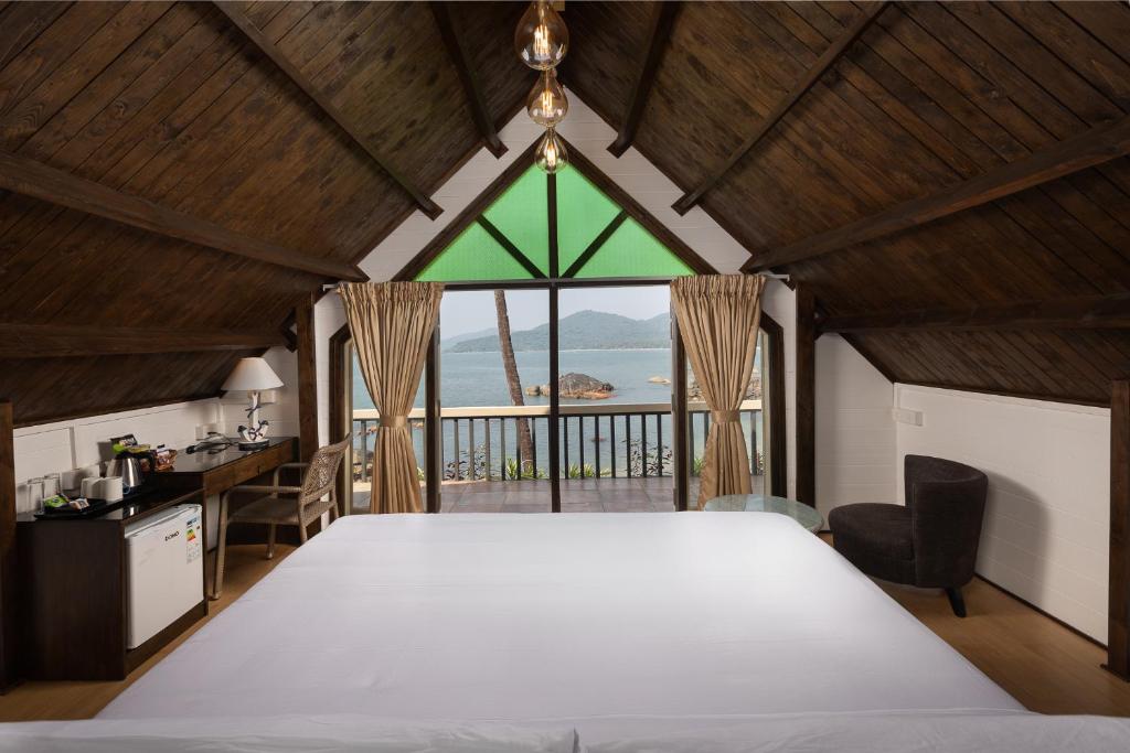 a bedroom with a large bed and a large window at The Ark Comforts in Palolem
