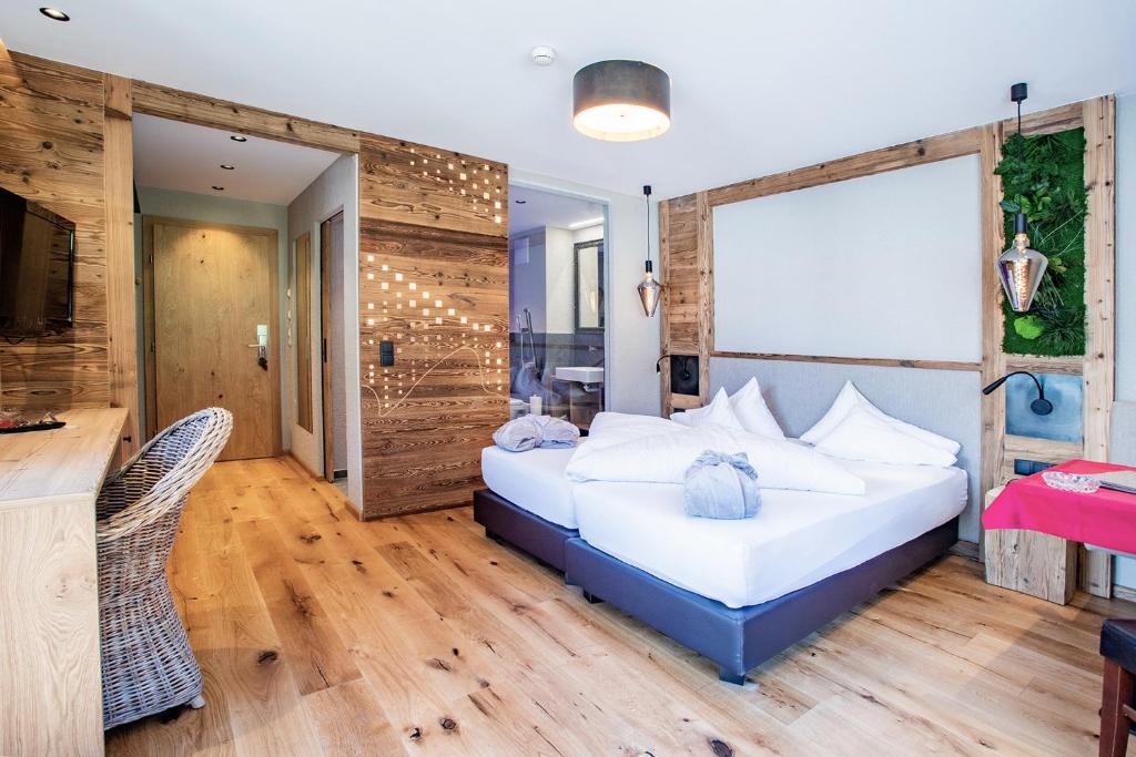 a bedroom with a bed and a wooden wall at Hundehotel Riederhof in Ried im Oberinntal
