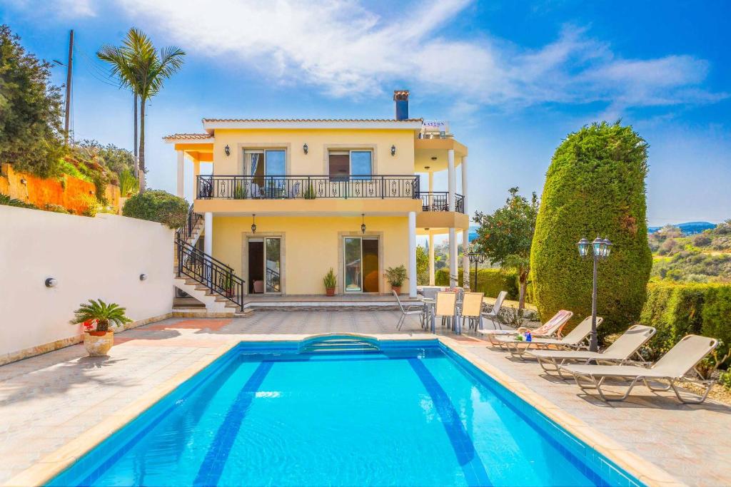 eine Villa mit einem Pool vor einem Haus in der Unterkunft Villa Wisteria in Lachi