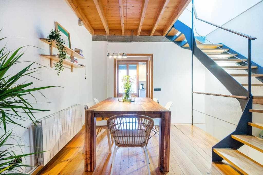 ein Esszimmer mit einem Tisch und einer Treppe in der Unterkunft Sleep y Stay Arab Baths Ático Apartment in Girona