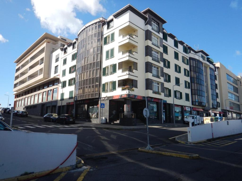Azores Apartment في بونتا ديلغادا: مبنى ابيض كبير على شارع المدينة