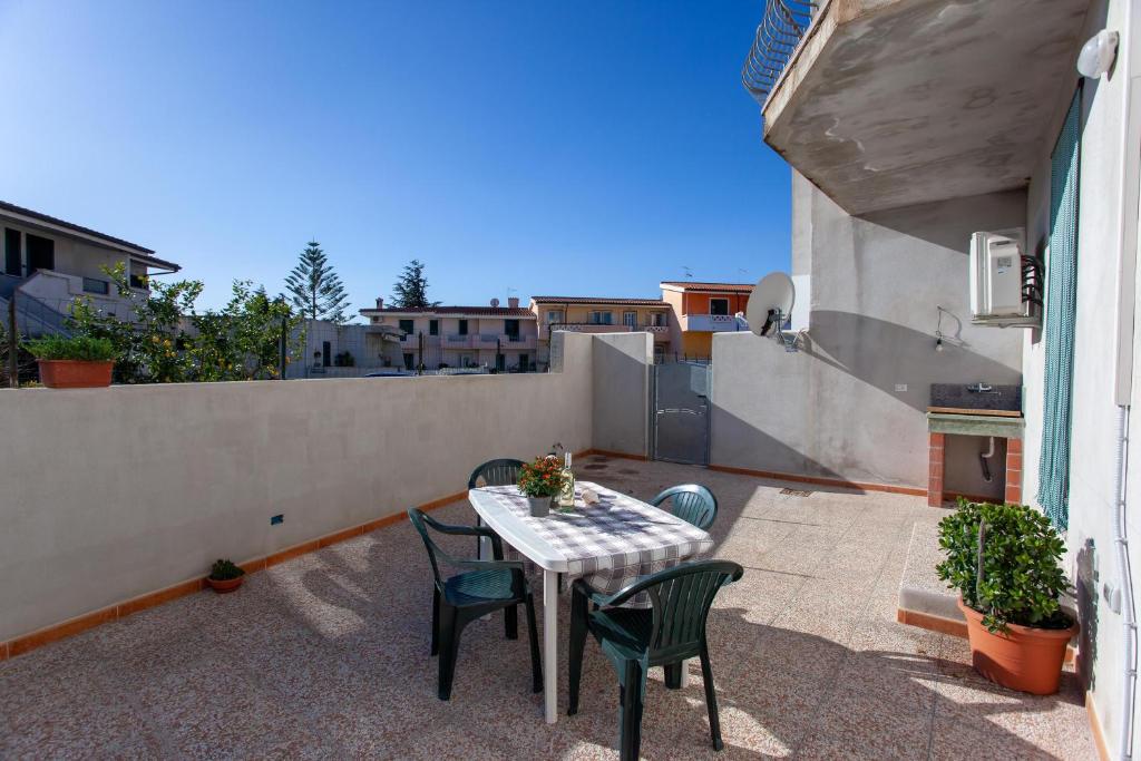 patio ze stołem i krzesłami na balkonie w obiekcie Casa Francesco w mieście Orosei