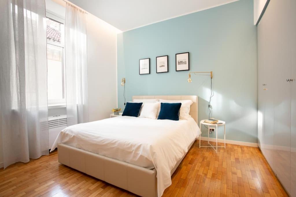 1 dormitorio con 1 cama blanca grande y paredes azules en Santa Chiara Suite en Turín