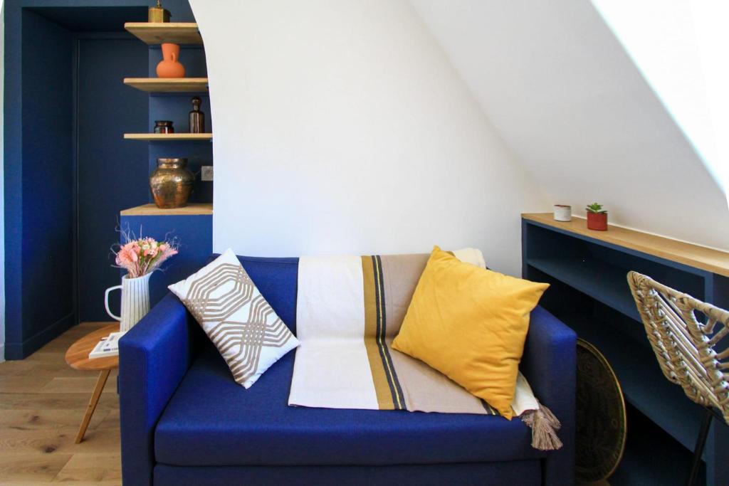 - un canapé bleu avec des oreillers dans l'établissement Charming 2-Room 21m Comfort Sacré-Cœur View, à Paris