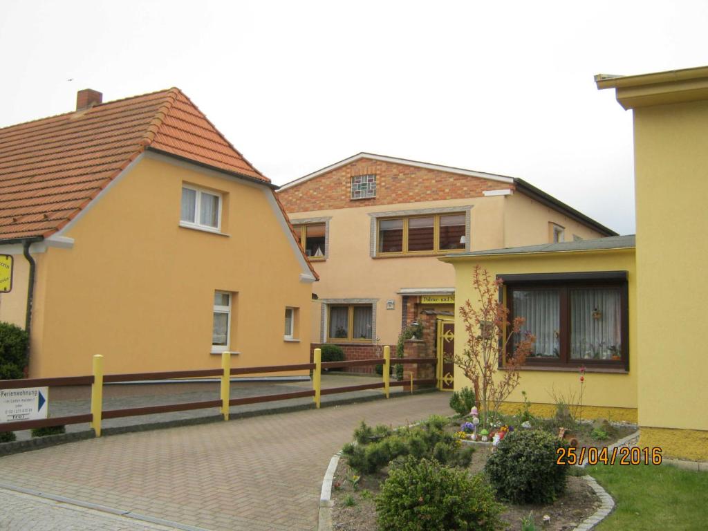 a yellow house with a fence in front of it at Ferienwohnung Dünensand in Kühlungsborn