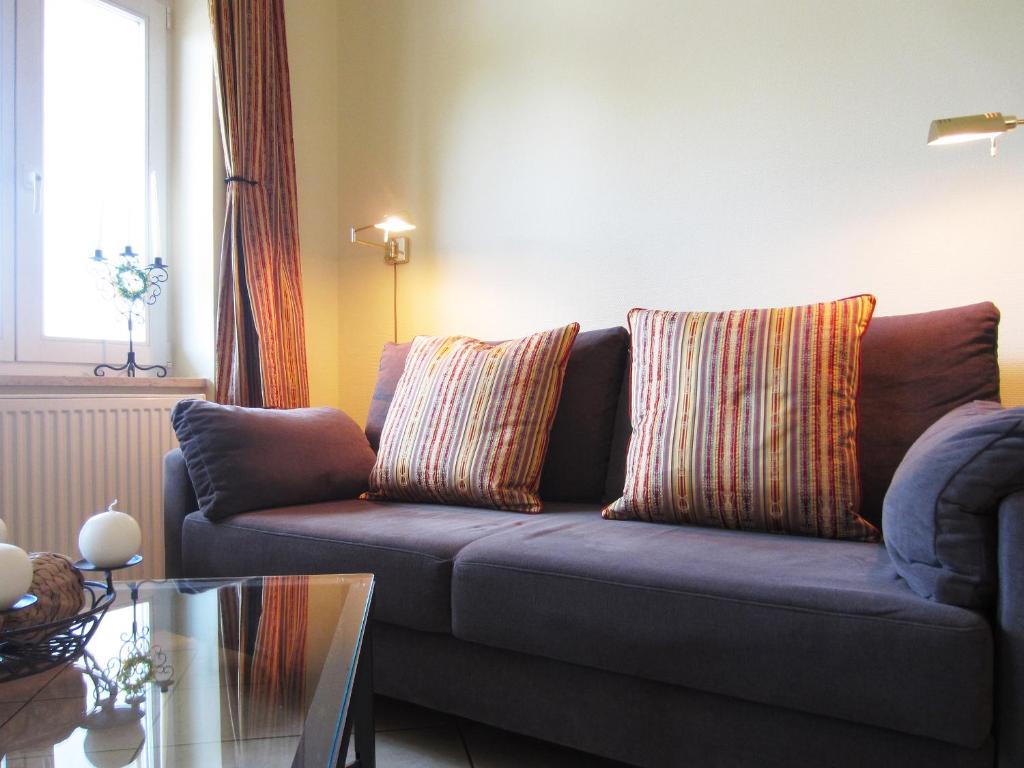 uma sala de estar com um sofá azul com duas almofadas em Ferienwohnung Seeadler Nr. 7 em Kühlungsborn