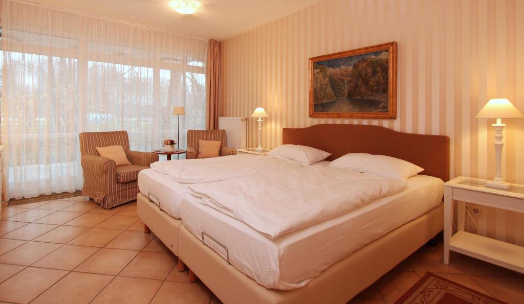 ein Schlafzimmer mit einem großen weißen Bett in einem Zimmer in der Unterkunft Ferienwohnung Antonia in Kühlungsborn
