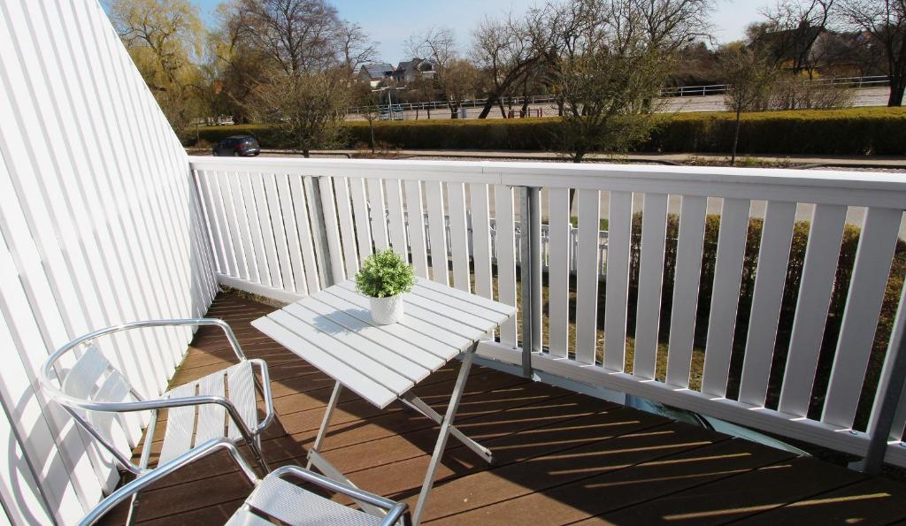 a white bench on a porch with a potted plant at Ferienwohnung Molliblick in Kühlungsborn