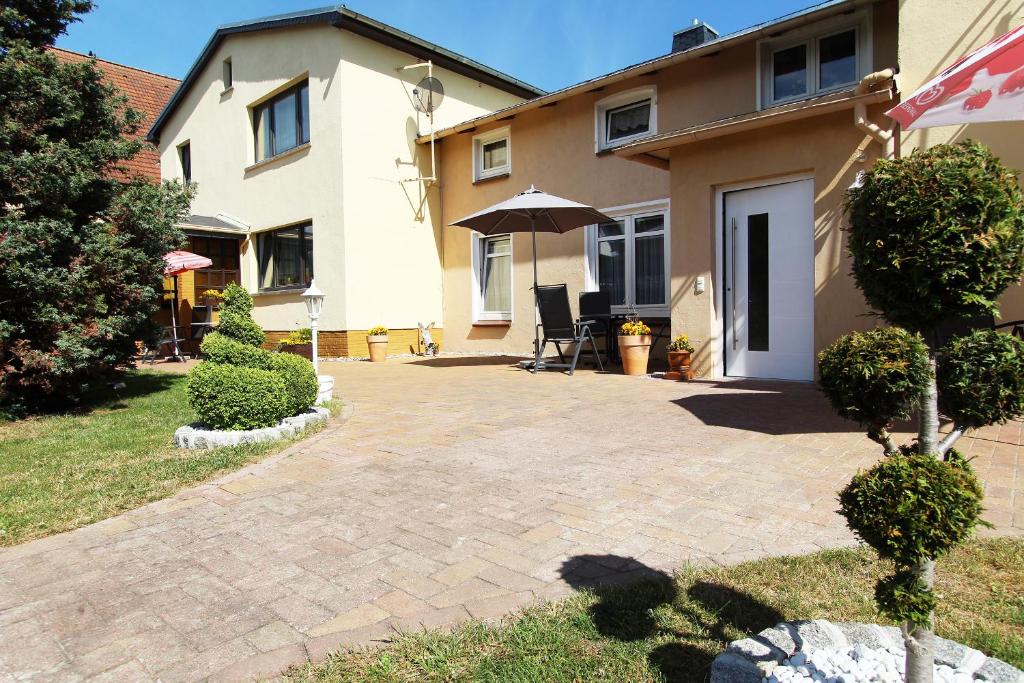 eine Terrasse vor einem Haus mit Sonnenschirm in der Unterkunft Ferienwohnung Iris in Kühlungsborn