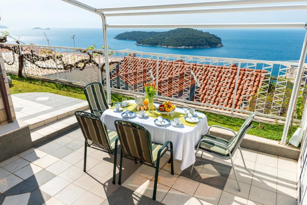 
a dining room table with a balcony overlooking the ocean at Apartments and Room Lora in Dubrovnik
