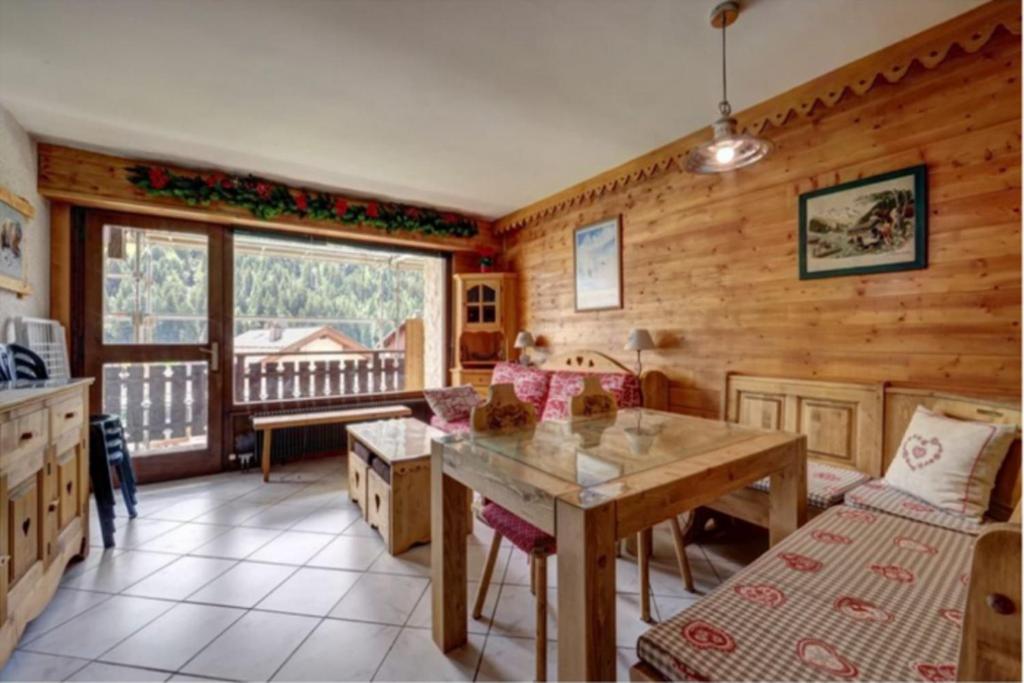 a kitchen with wooden walls and a table in a room at Studio with balcony in the center of the village in Le Grand-Bornand