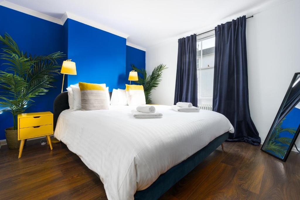 sypialnia z dużym łóżkiem z niebieskimi ścianami w obiekcie Vibrant Spring Street with Garden w Brighton and Hove