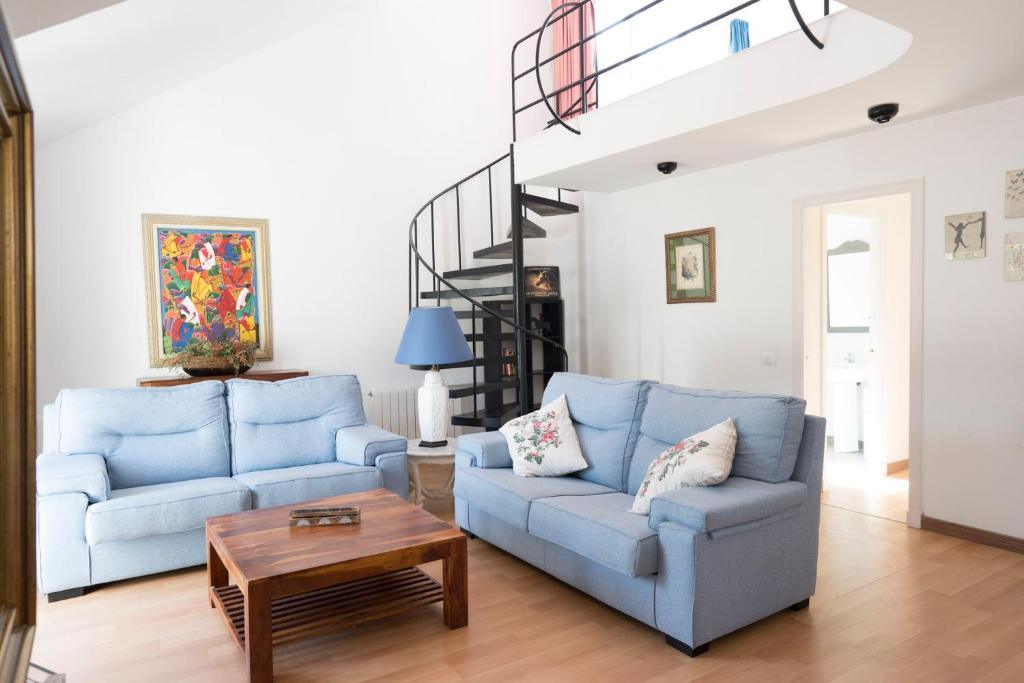 a living room with two blue couches and a table at Orquideas in Cala Galdana
