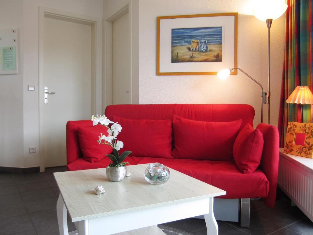 ein Wohnzimmer mit einem roten Sofa und einem Couchtisch in der Unterkunft Ferienwohnung Waldblick Nr. 17 in Kühlungsborn