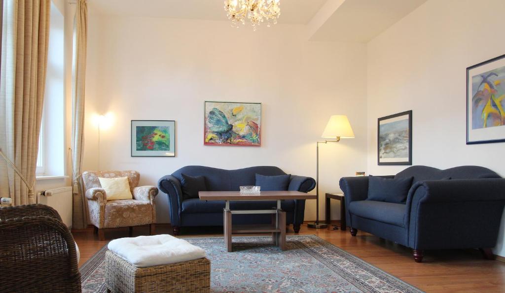 ein Wohnzimmer mit 2 blauen Stühlen und einem Tisch in der Unterkunft Ferienwohnung Soldo in Kühlungsborn