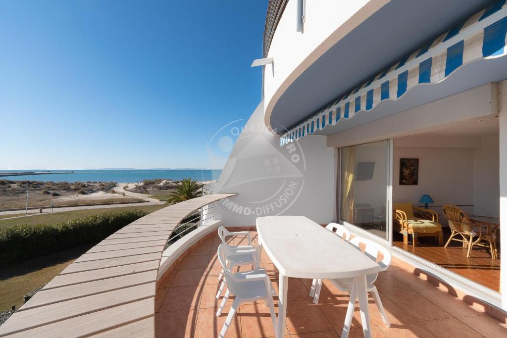 un balcon d'une maison avec une table et des chaises dans l'établissement AS4269 - Studio cabine direct sur plage vue mer et parking privé et numéroté, au Grau-du-Roi