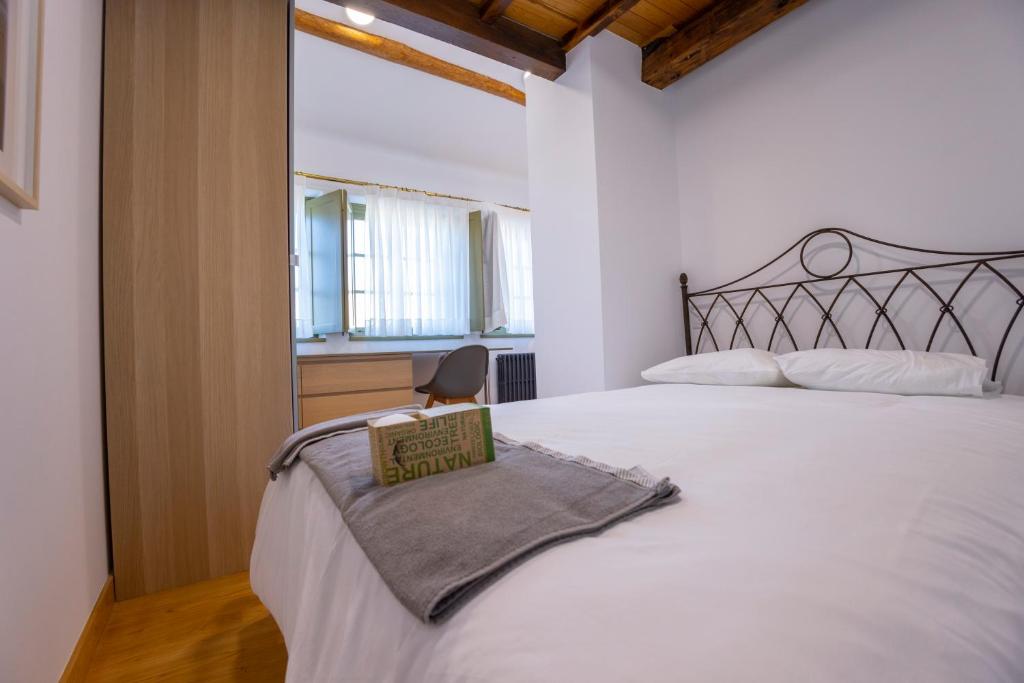 1 dormitorio con 1 cama blanca grande y 1 silla en Casa Alameda 33 en Ría Eo-Ribadeo, en Castropol