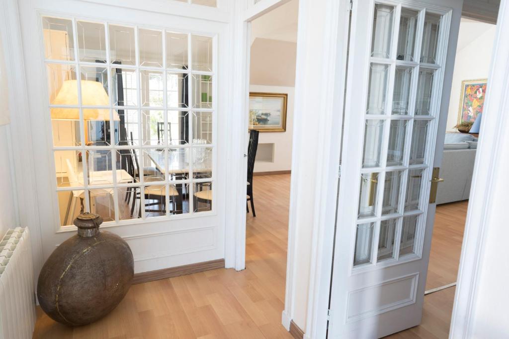 a room with white walls and a doorway with glass doors at Orquideas in Cala Galdana