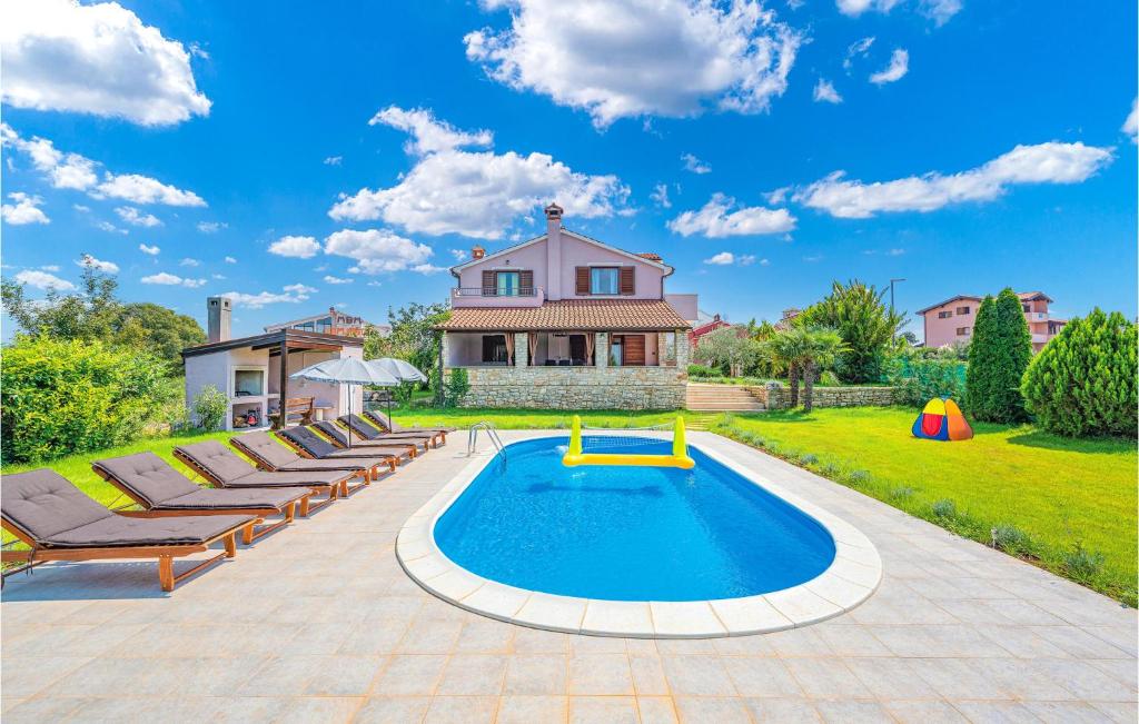 a pool with lounge chairs and a house at Stunning Home In Bale With 4 Bedrooms, Wifi And Outdoor Swimming Pool in Bale