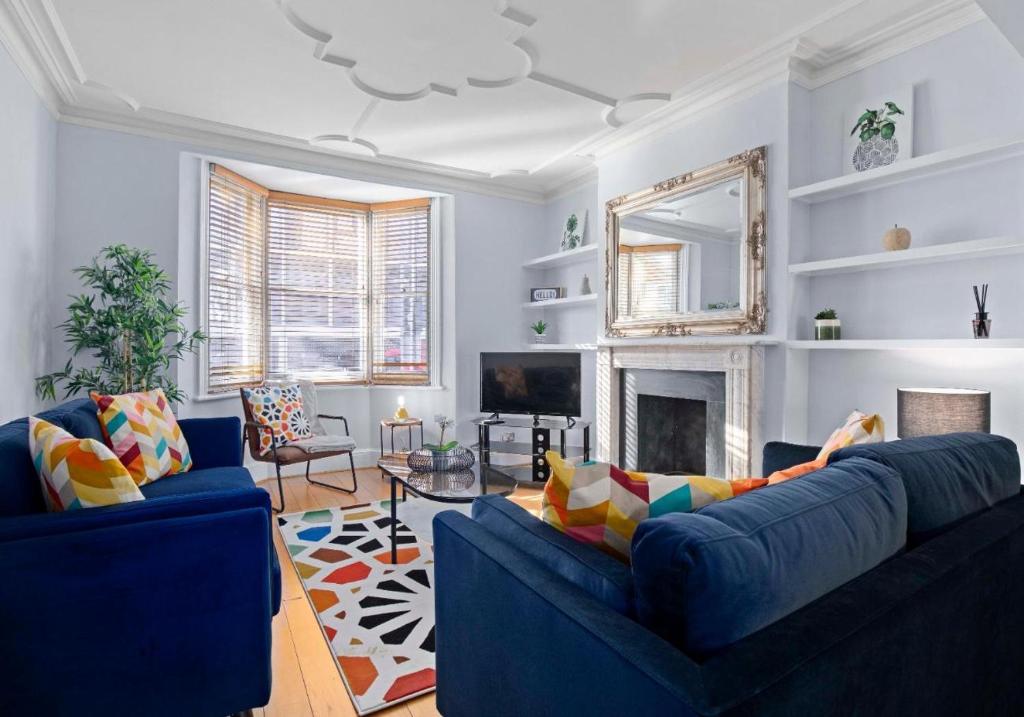 - un salon avec deux canapés bleus et une cheminée dans l'établissement The Townhouse By My Getaways Free Parking, à Brighton et Hove