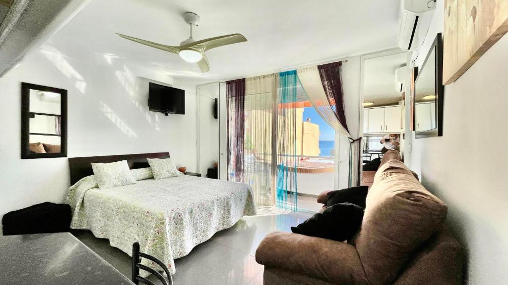 salon z łóżkiem i kanapą w obiekcie Bulto Carihuela w mieście Torremolinos