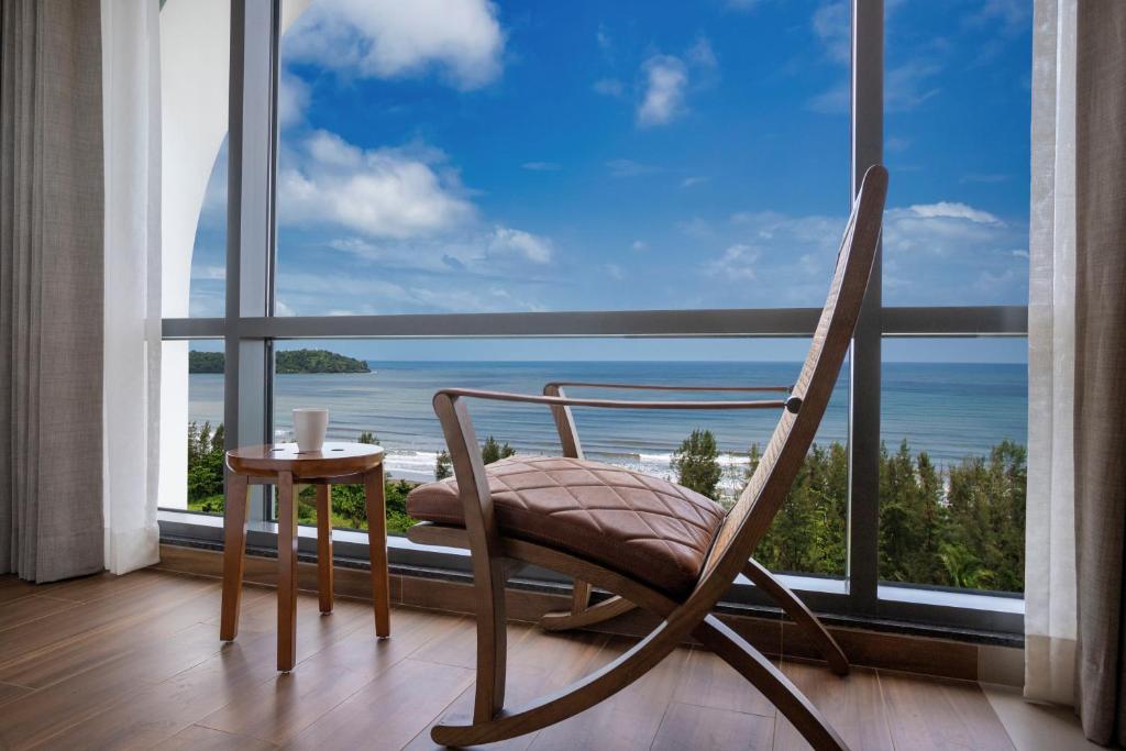 a rocking chair sitting in front of a large window at The Crescent in Panaji