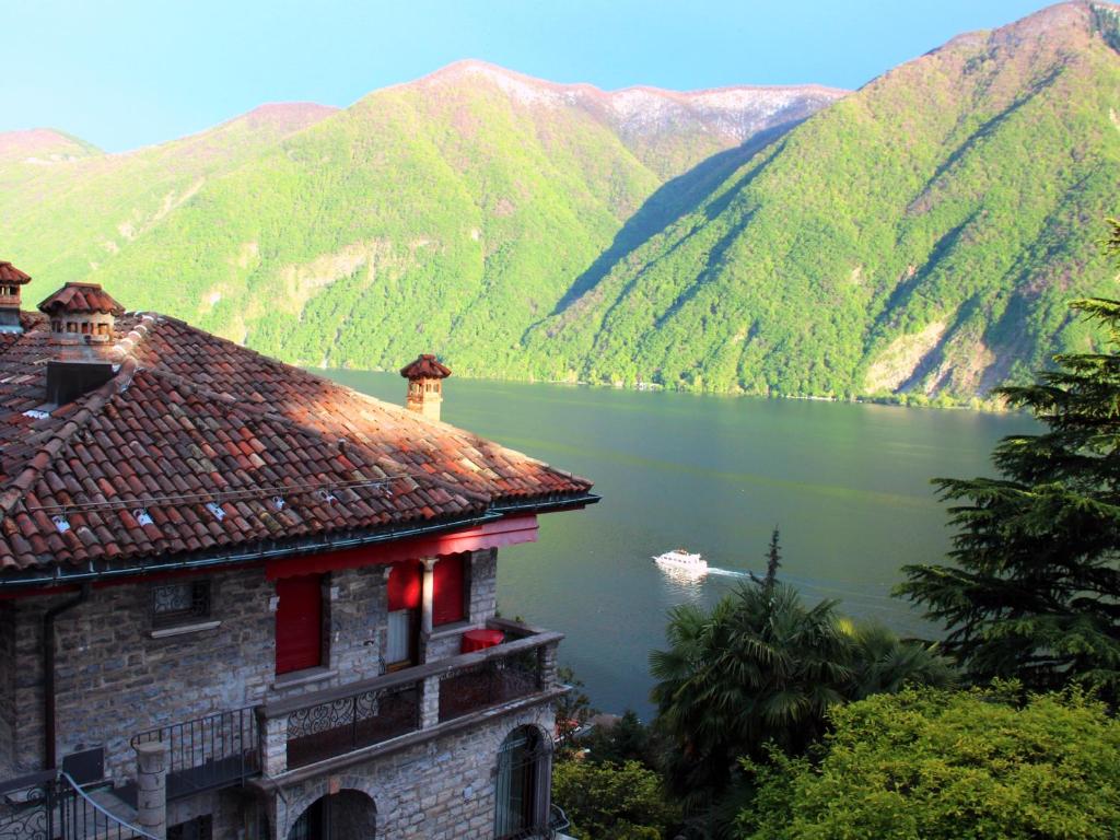 ルガノにあるBarony Le Pergole holiday apartments Luganoの湖と山の景色を望む建物