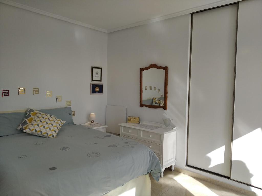 um quarto com uma cama, um espelho e uma janela em Belle Vue em Ciudad Quesada