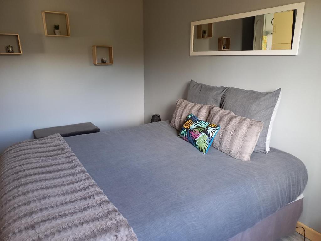 ein Bett mit zwei Kissen darauf in einem Schlafzimmer in der Unterkunft Maison au pied du Mont Saint Michel in Pontorson