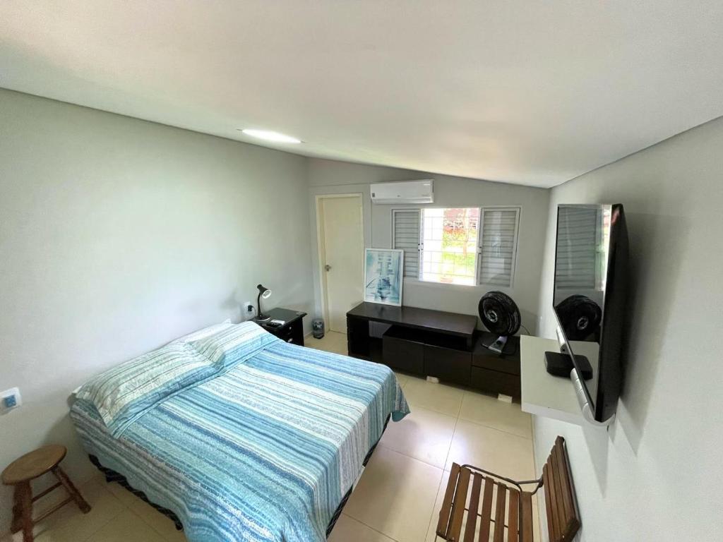 un dormitorio con una cama y un escritorio en Suite Confortavel em Chapada dos Guimaraes, en Chapada dos Guimarães