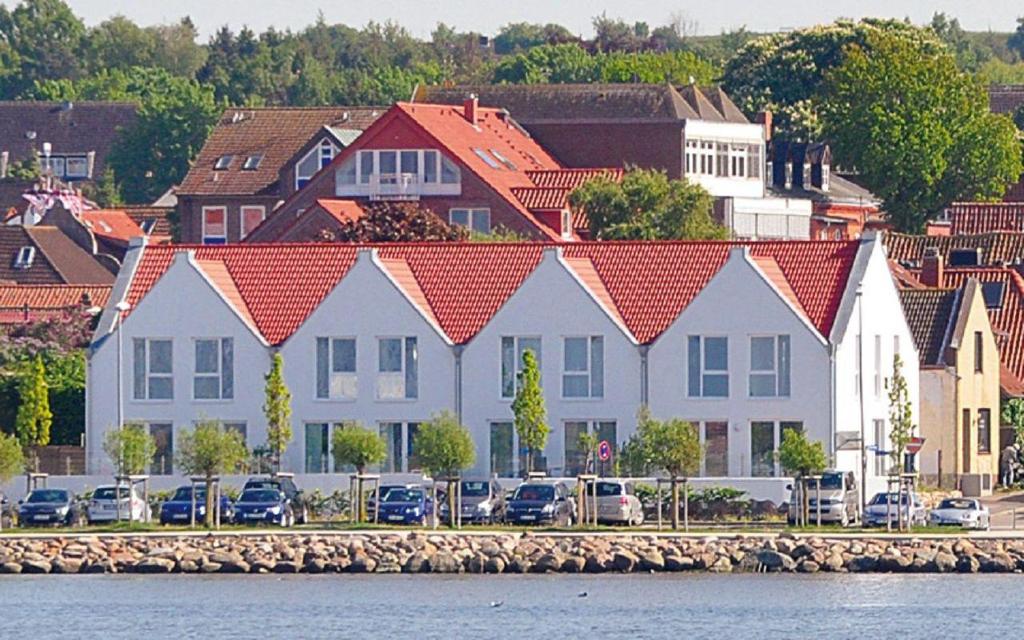 eine Reihe von Häusern mit Autos neben dem Wasser in der Unterkunft Ferienhaus "Lee" in Heiligenhafen