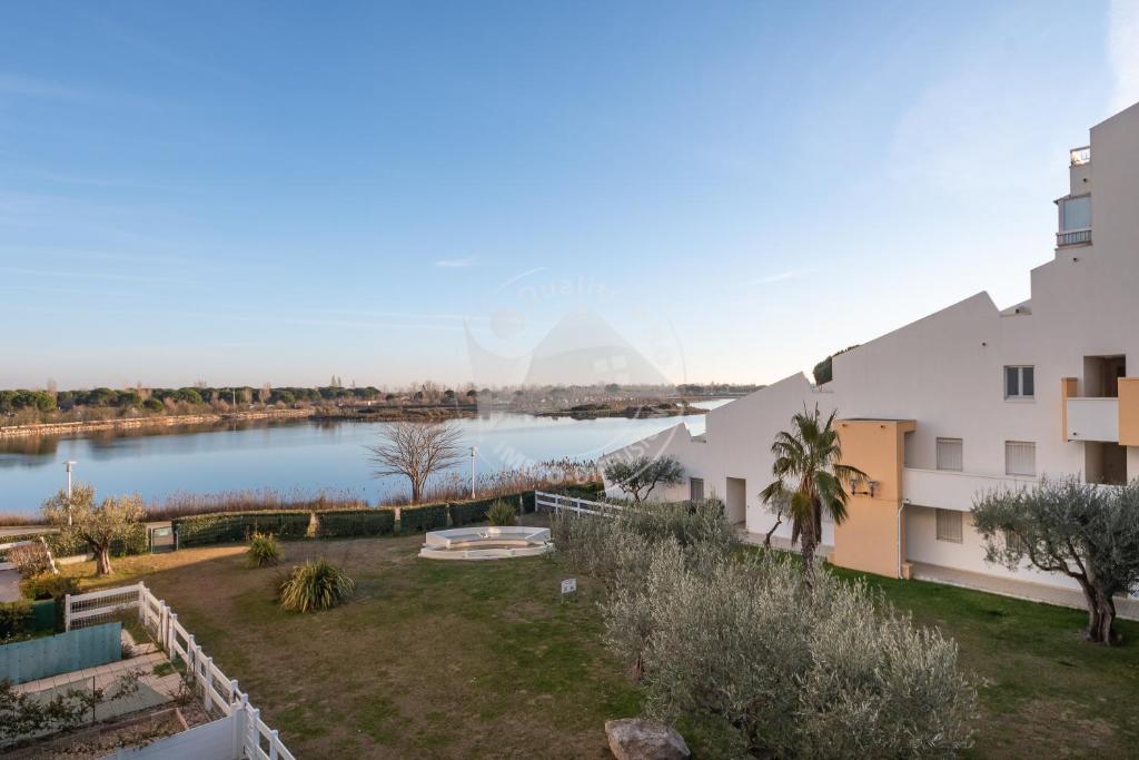 Vue aride d'un bâtiment avec une masse d'eau dans l'établissement AS16245 - P2 Belle vue lac avec parking privé, au Grau-du-Roi