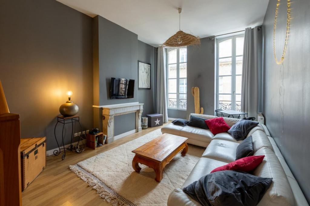 een woonkamer met een bank en een salontafel bij Contemporary Furnished Duplex With 3 Bedrooms Near All Amenities in Bordeaux
