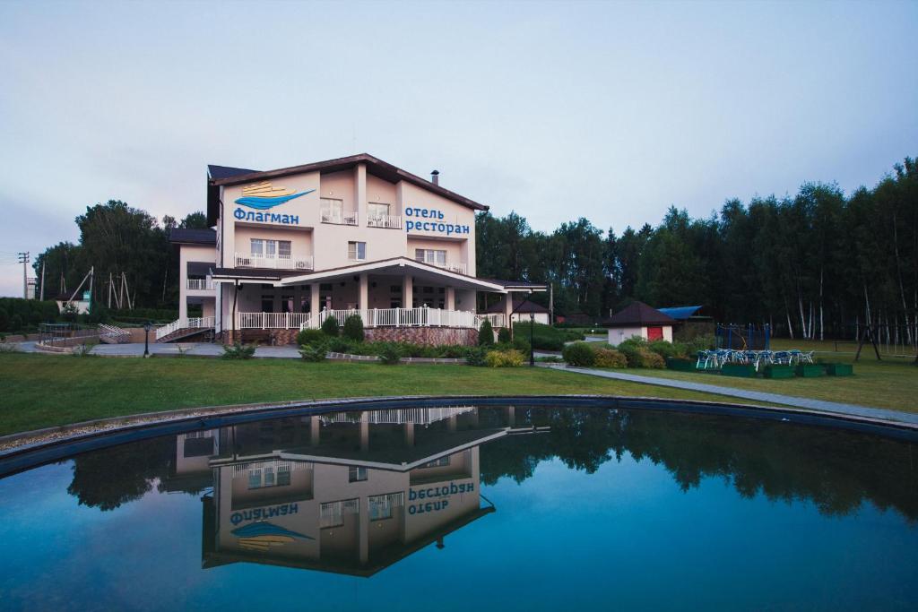 ein Gebäude mit einem Pool mit Wasser davor in der Unterkunft Flagman Hotel in Novovolkovo