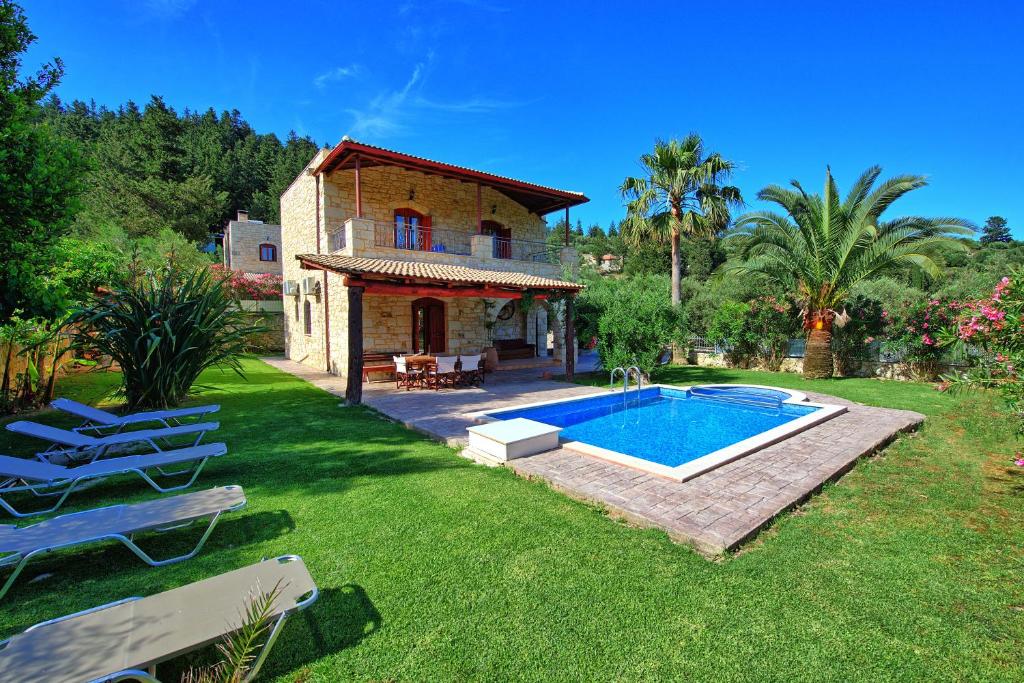 uma casa com piscina num quintal em Villa Vrisses by PosarelliVillas em Vryses