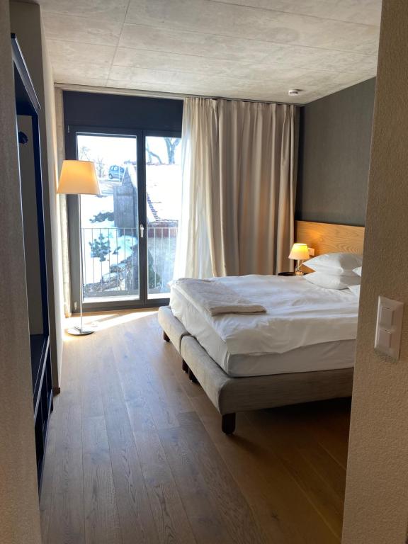 una camera da letto con un letto e una grande finestra di Hotel de l’Ours Preles a Prêles