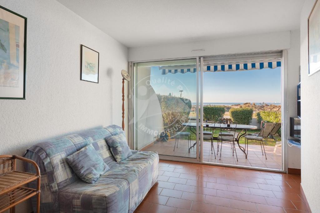un salon avec un canapé et une table avec vue dans l'établissement AS8313 - P2 cabine avec parking privé, accès direct à la plage, au Grau-du-Roi
