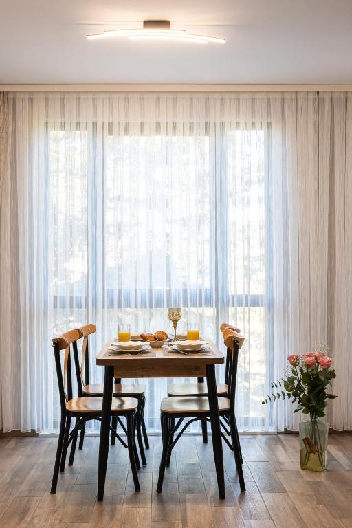 a dining room with a table and chairs in front of a window at Helena Holiday A in Saints Constantine and Helena