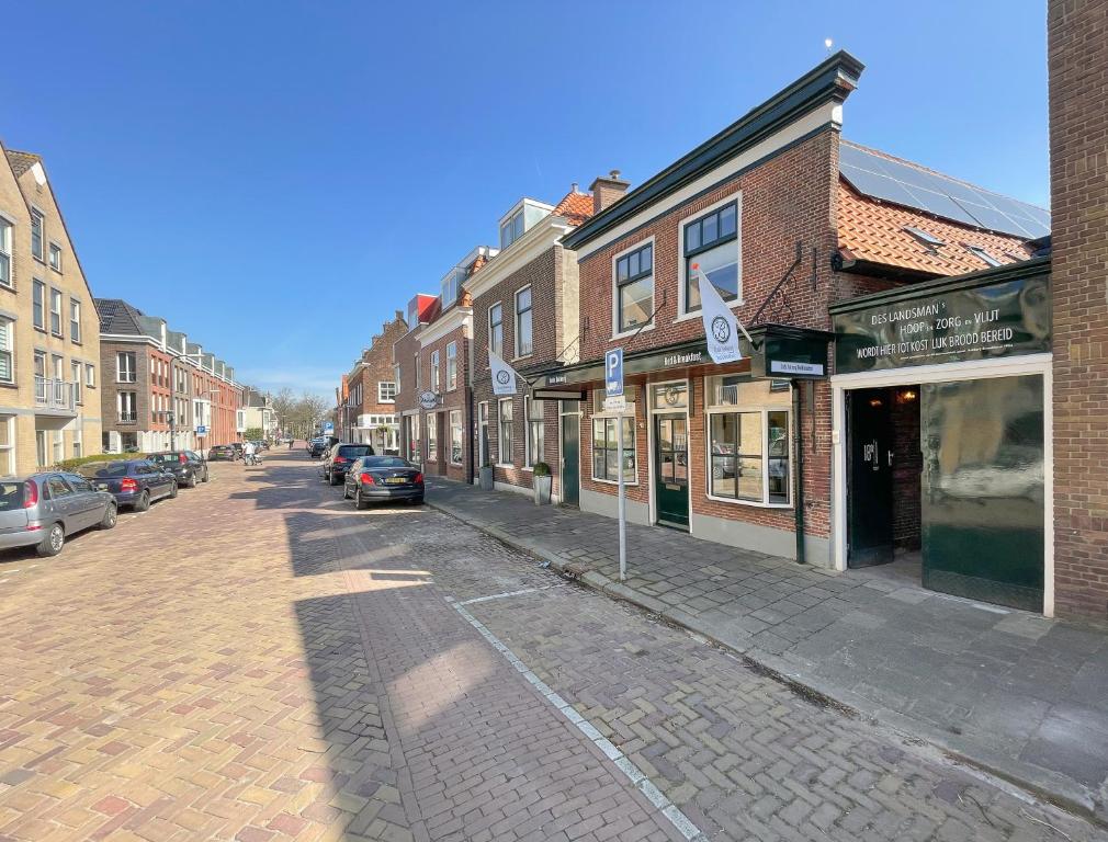 uma rua com edifícios e carros estacionados na rua em Bed & Breakfast Oude Bakkerij em Rijswijk