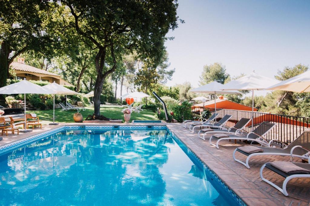 - une piscine avec des chaises longues et des parasols dans l'établissement Hotel****Spa & Restaurant Cantemerle, à Vence