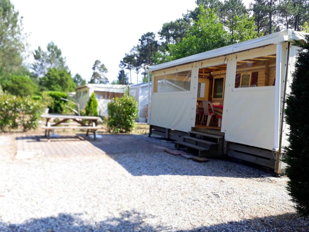 Une petite maison avec une table de pique-nique dans une cour dans l'établissement Bungalow charmant à Saint-Julien-en-Born avec piscine partagée, à Saint-Julien-en-Born