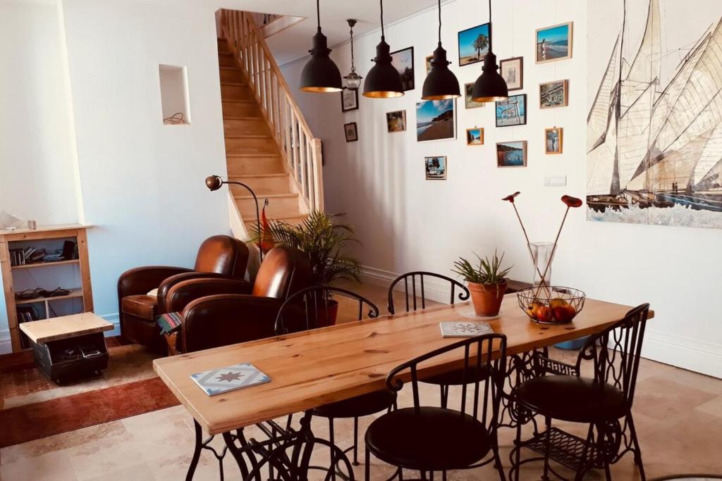 uma sala de jantar com uma mesa de madeira e cadeiras em Charming House Ideally Located With Furnished Terrace 3 Bedrooms & Parking em Le Bouscat