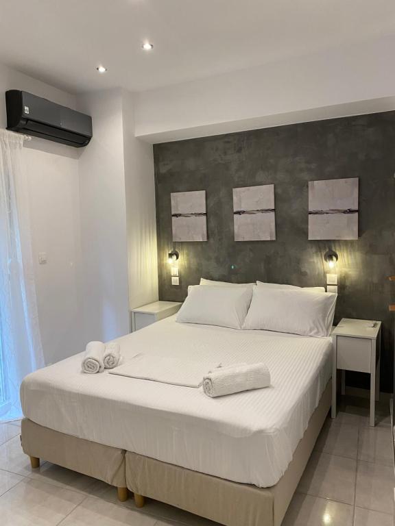 um quarto com uma grande cama branca com toalhas em George House em Atenas